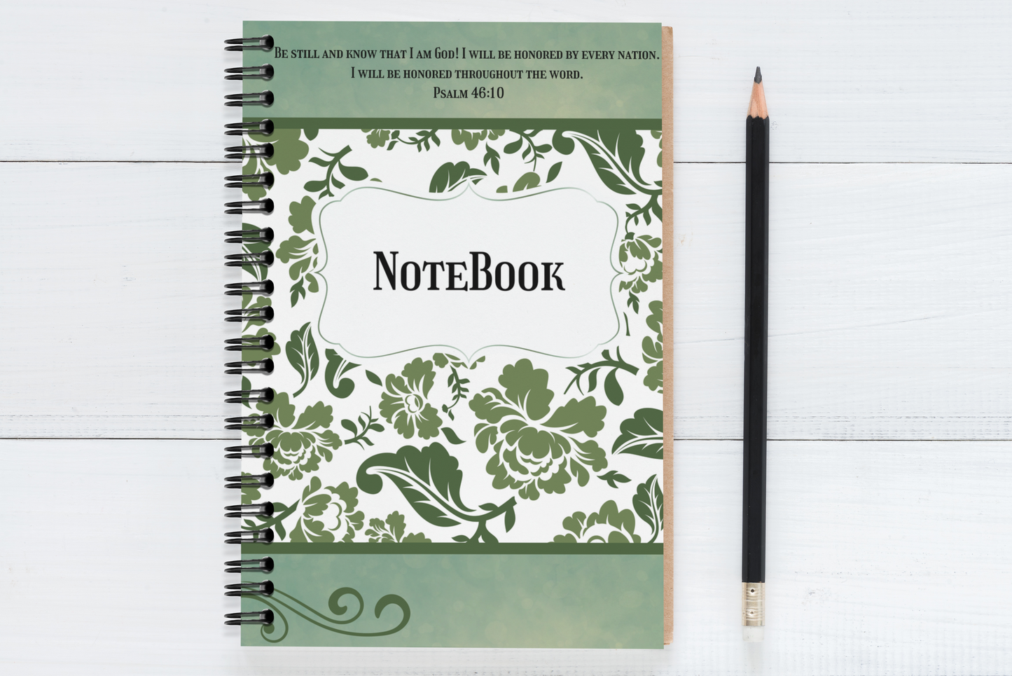 Notebook with floral design and text on a white wooden surface with a pencil.