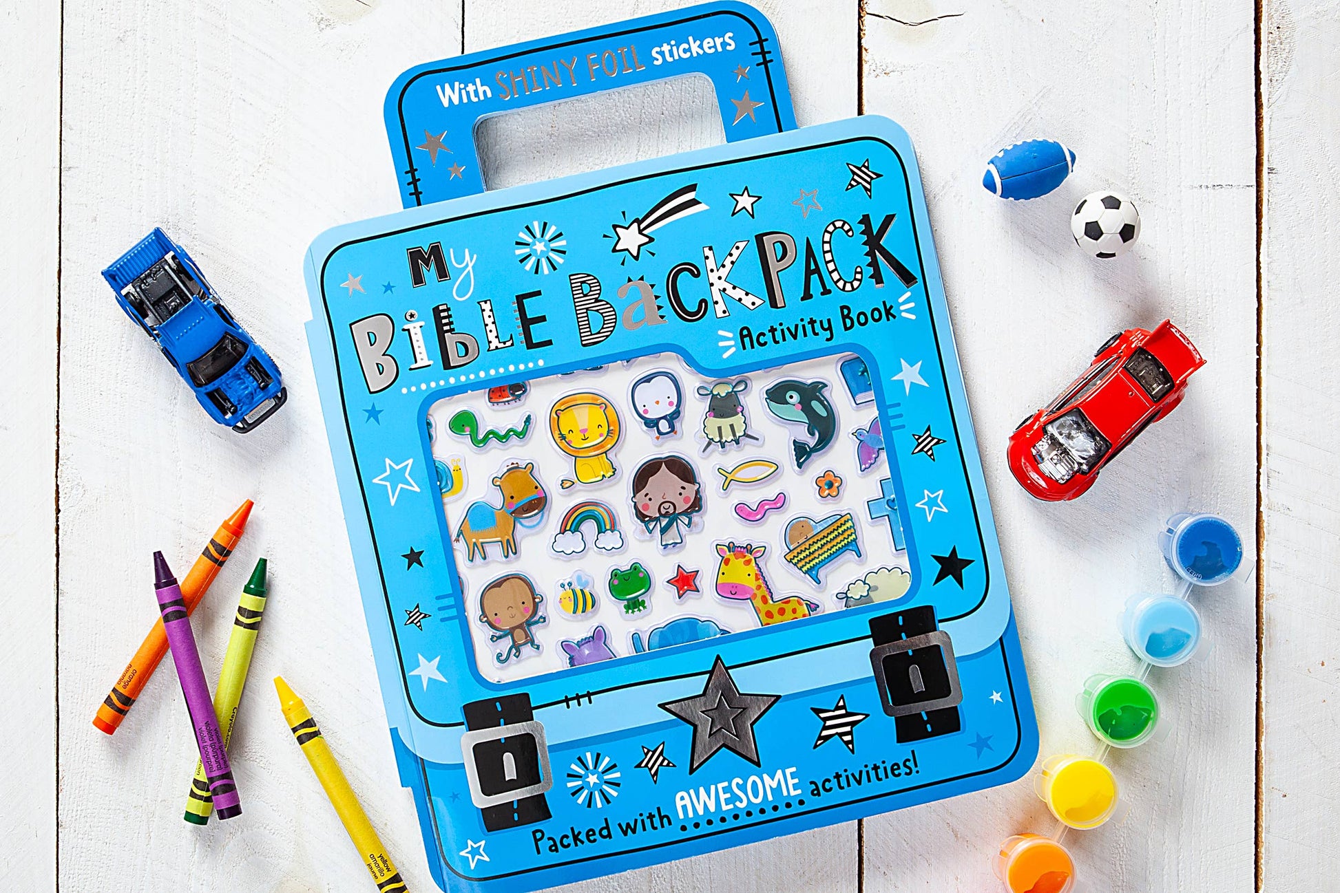 Children's Blue activity book on a wooden surface with crayons and stickers.