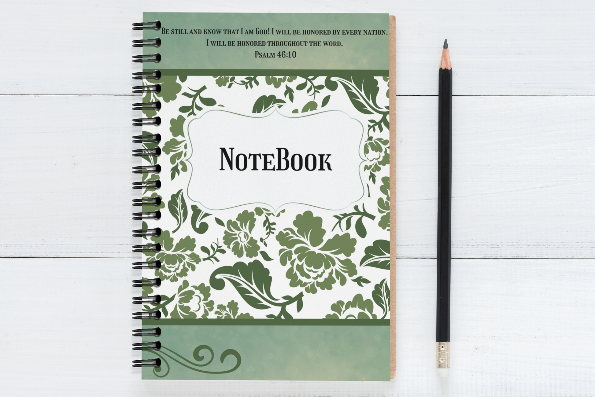 Notebook with floral design and text on a white wooden surface with a pencil.