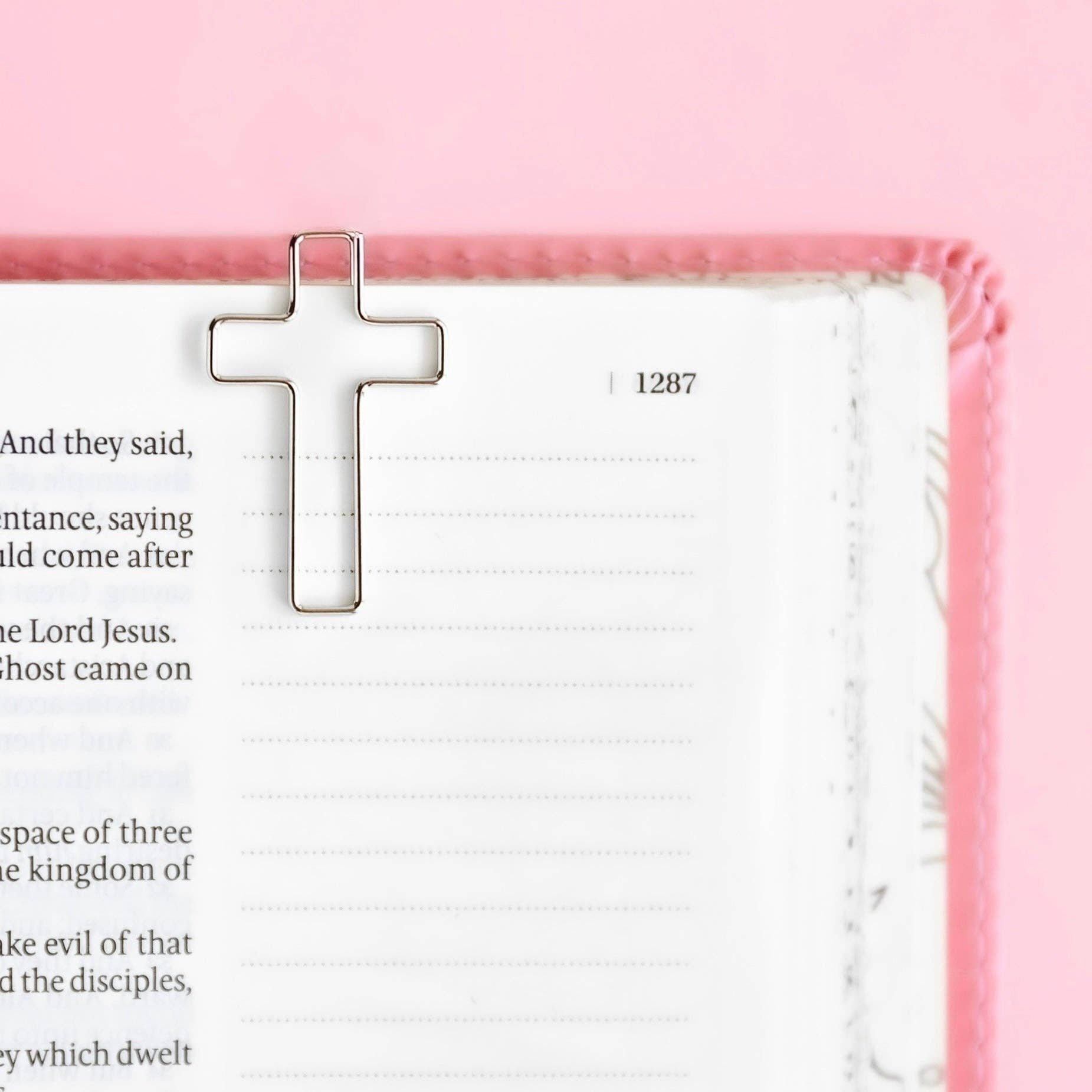 White cross on a pink background with text