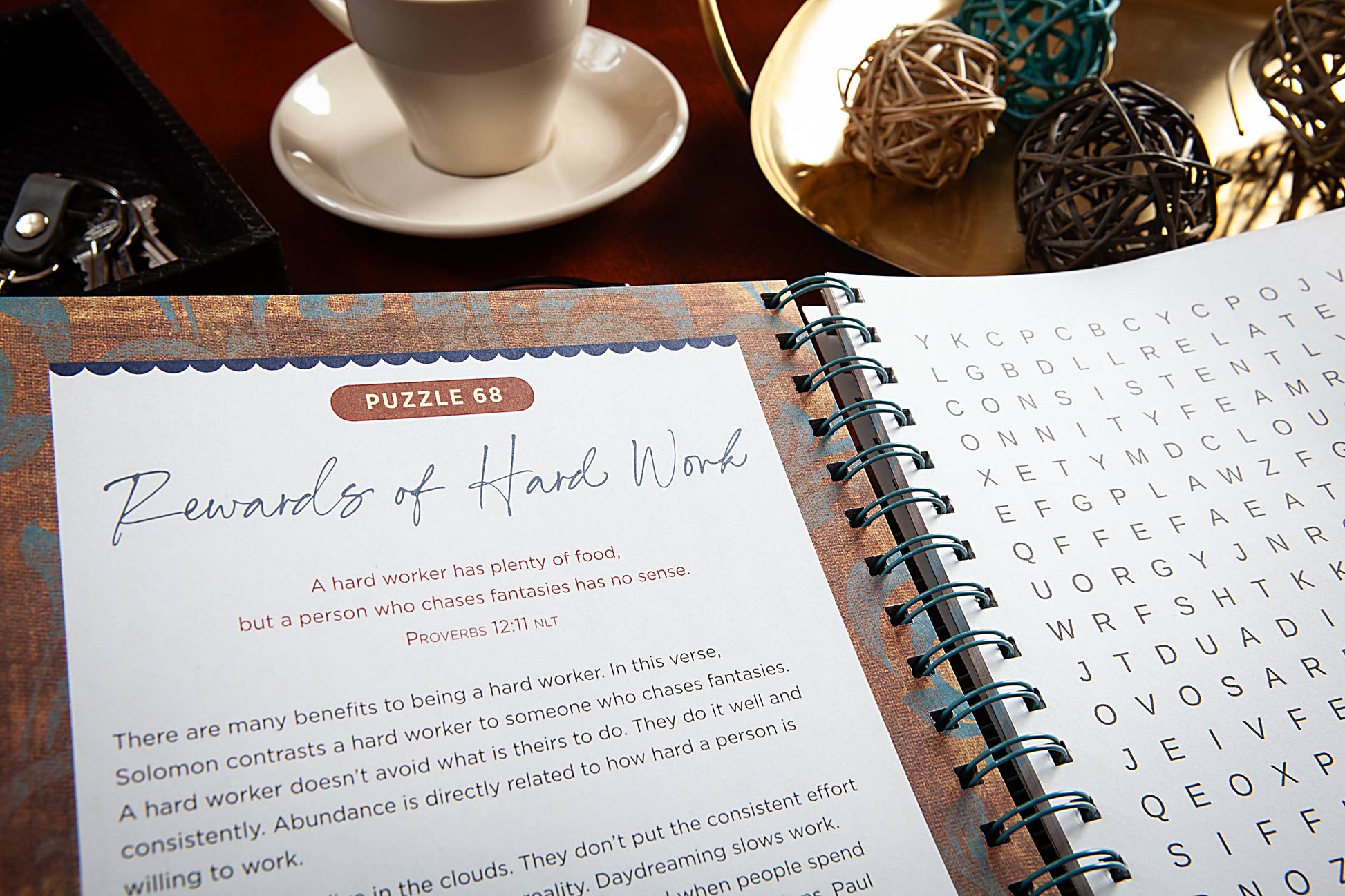 Open Bible Word Search devotional book on a wooden surface with a pen and phone.