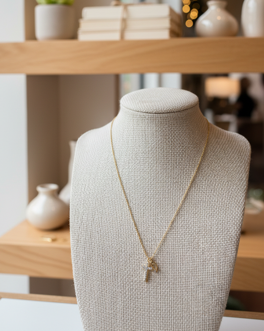 Gold necklace on a mannequin bust with a blurred indoor setting