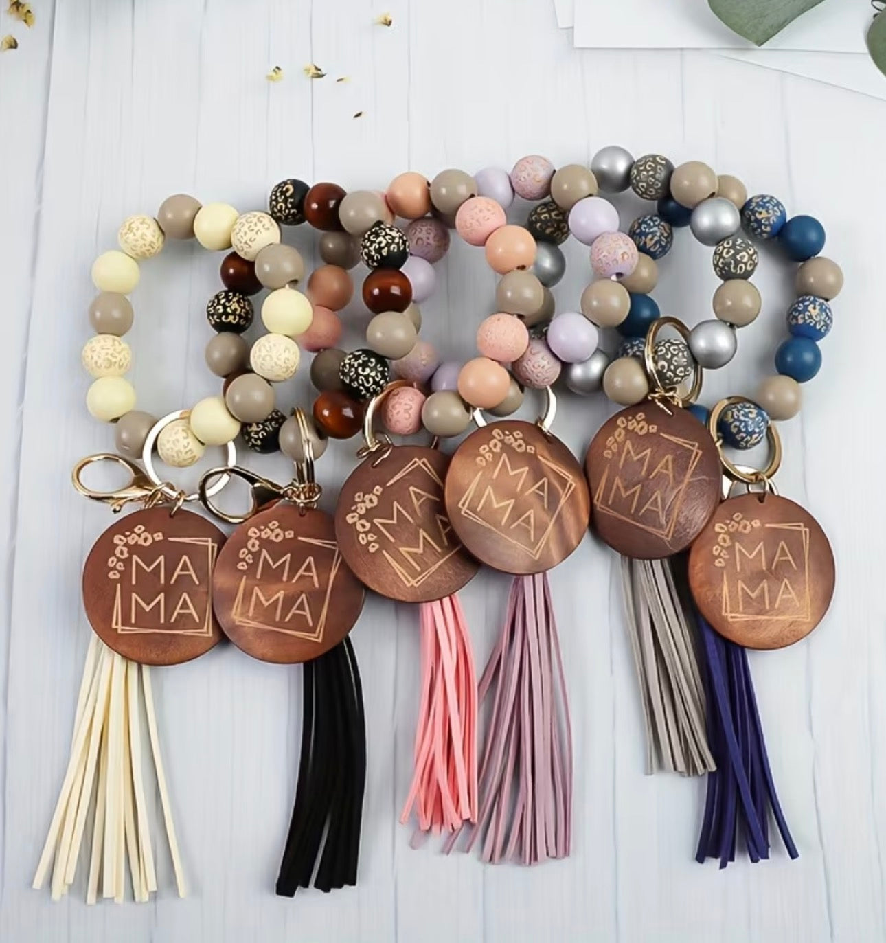 Set of beaded keychains with 'MAMA' tags and colorful tassels on a white background