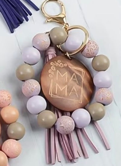 Keychain with colorful beads and wooden tag engraved with 'MALMA' on a light background
