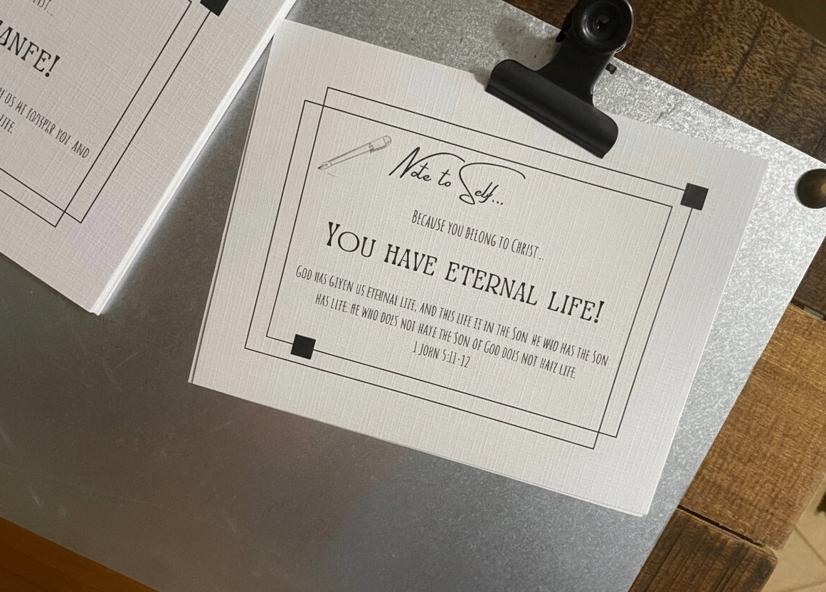 White scripture cards with black text on a clipboard on a wooden surface