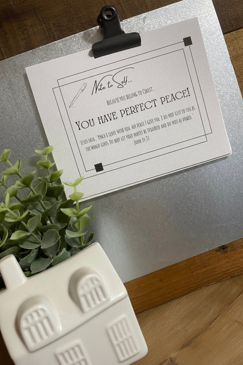 White scripture cards on a clipboard next to a plant and decorative item.