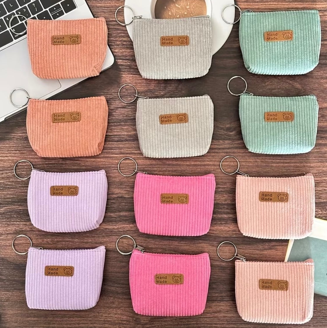 Collection of small fabric pouches in various colors on a wooden surface.