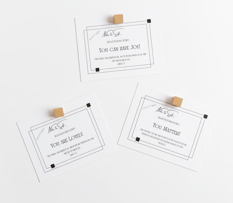 Four white scripture cards with black text on a white magnetic board with square wooden magnets to hold them in place. 