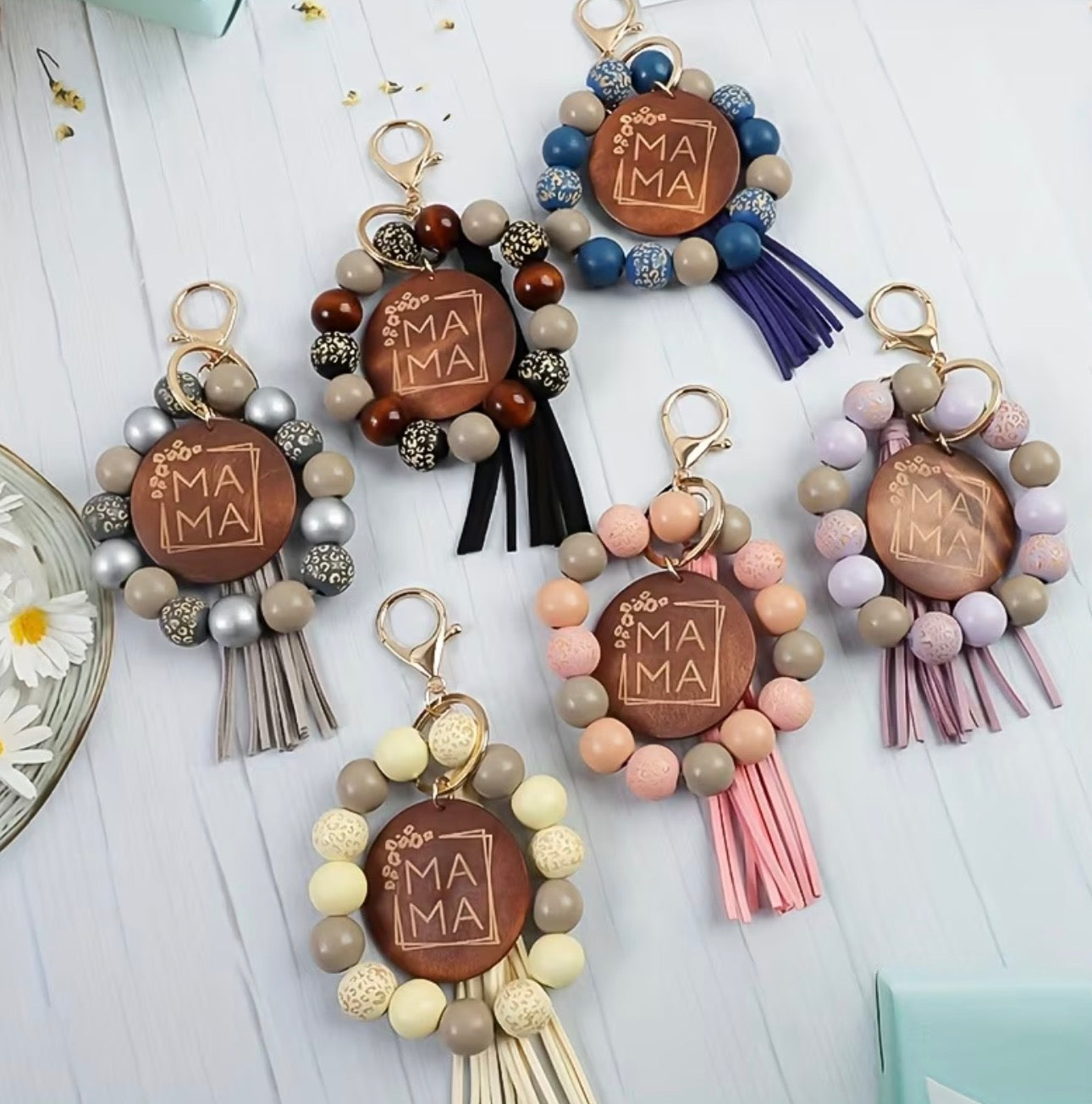 Keychains with 'MAMA' engraving on a wooden disc, featuring colorful beads and tassels.
