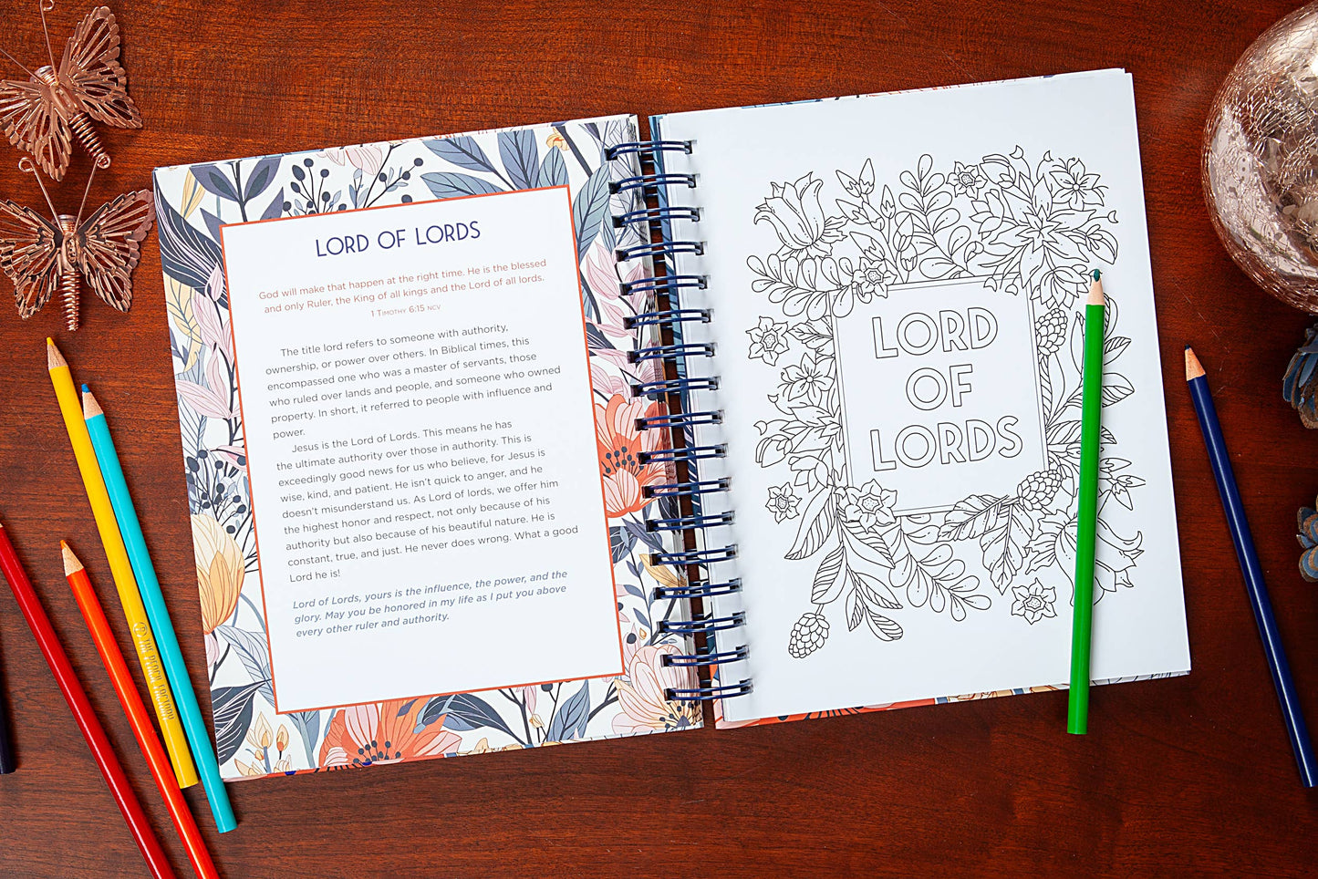 Coloring book open to a page with 'Lord of Lords' text and illustrations on a wooden surface with coloring pencils.