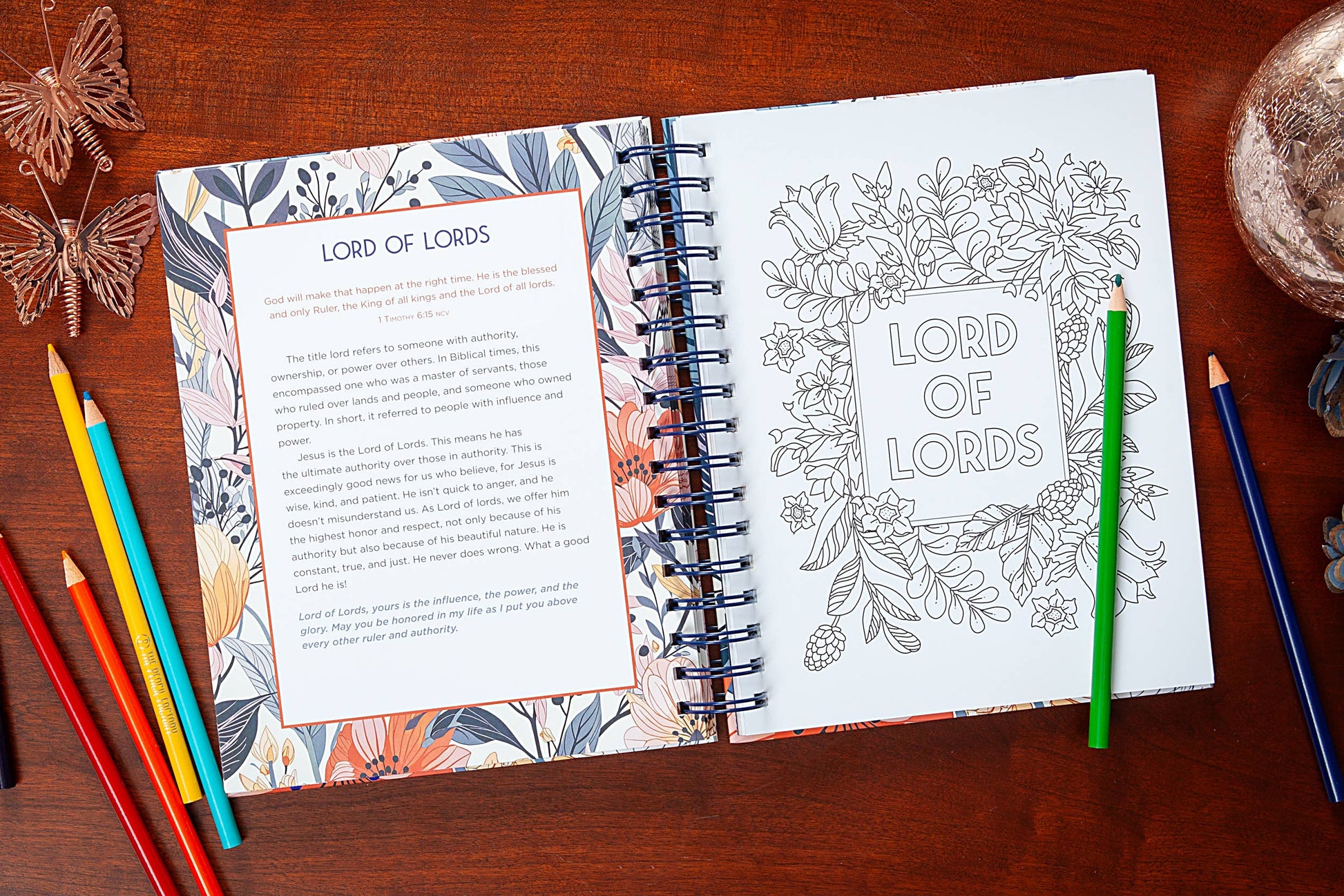 Coloring book open to a page with 'Lord of Lords' text and illustrations on a wooden surface with coloring pencils.